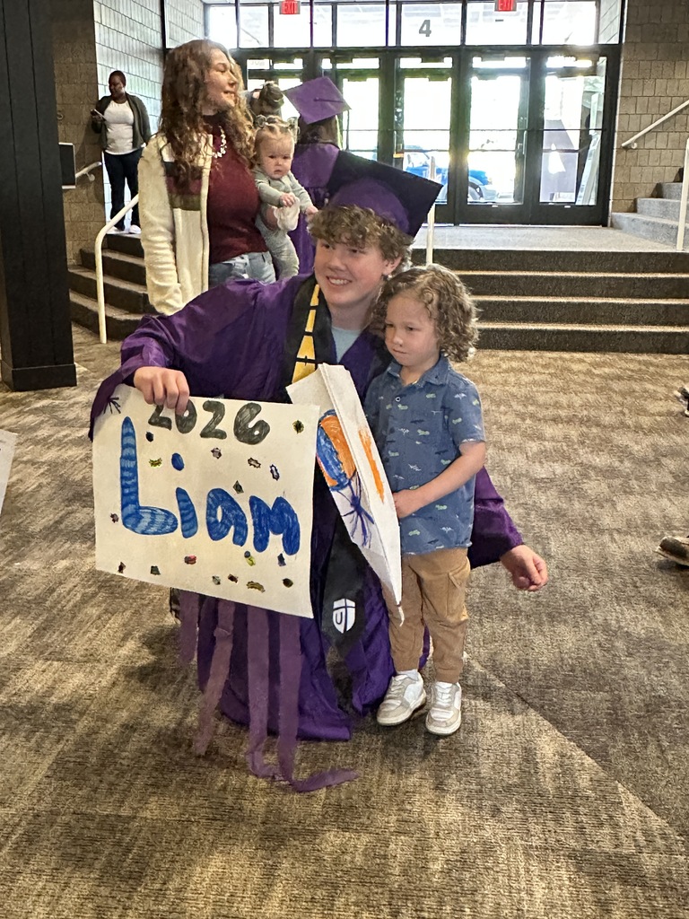senior in cap and gown with a pre-k student