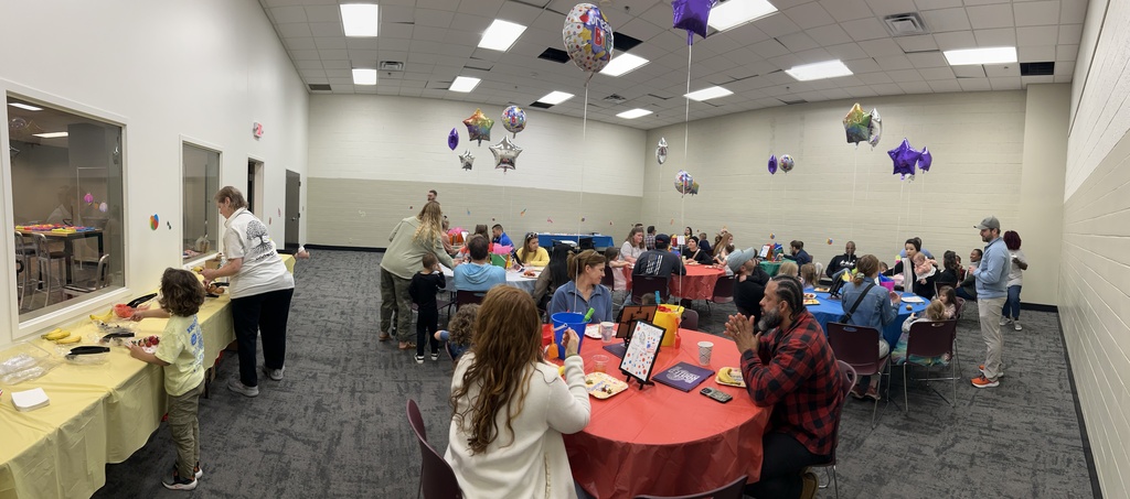 large room with people eating at round tables