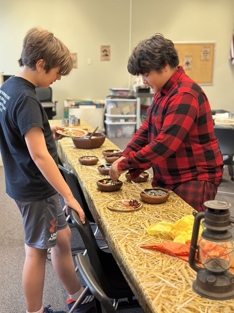 two boys getting snacks from a snack table
