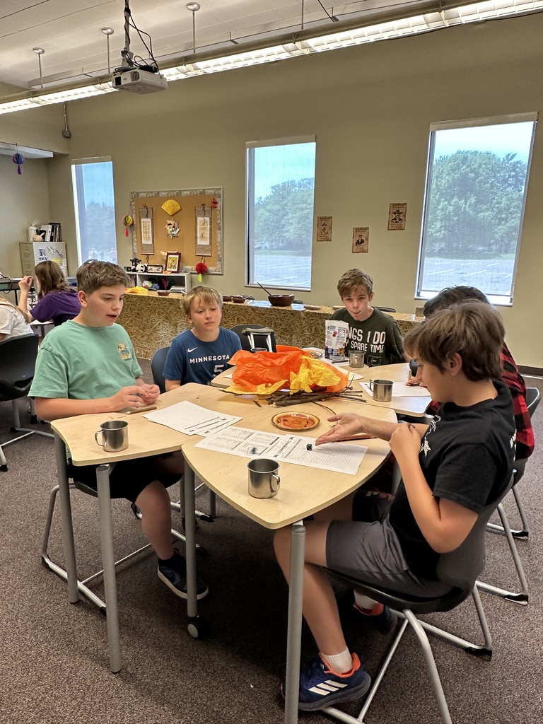 group of boys sitting at a table playing a game