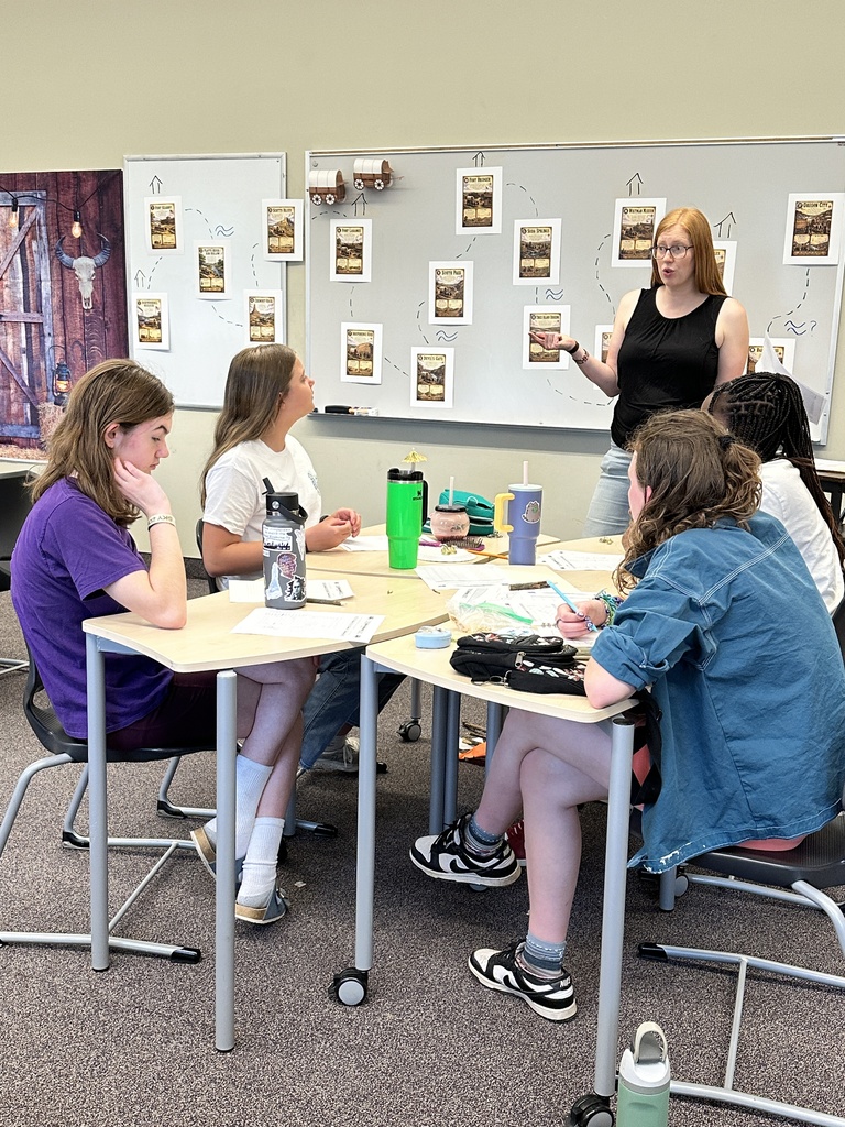 teacher speaking to a table of middle school girls