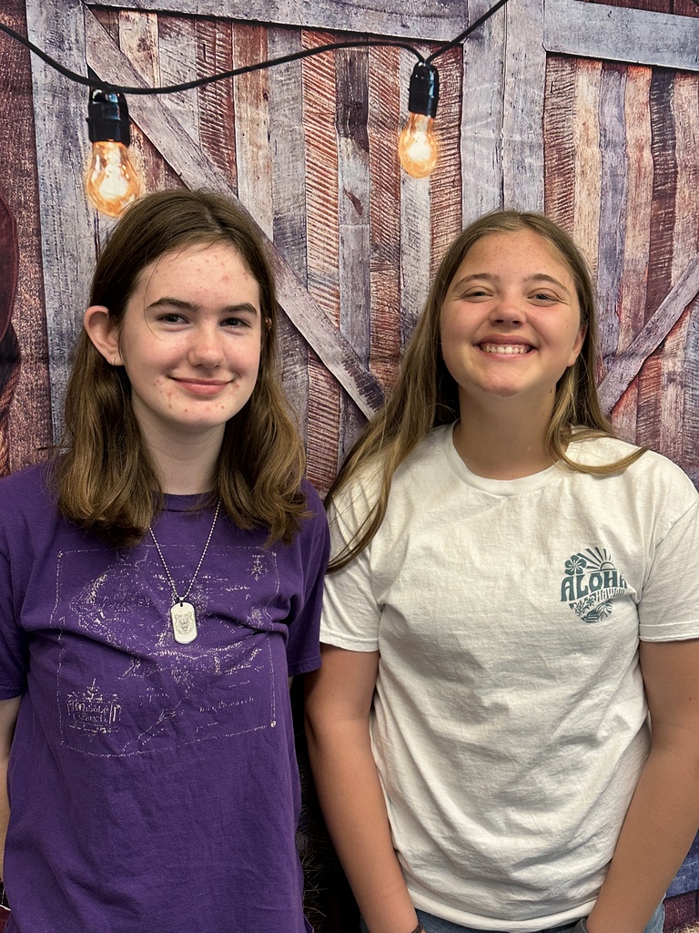 two girls in front of a photo backdrop