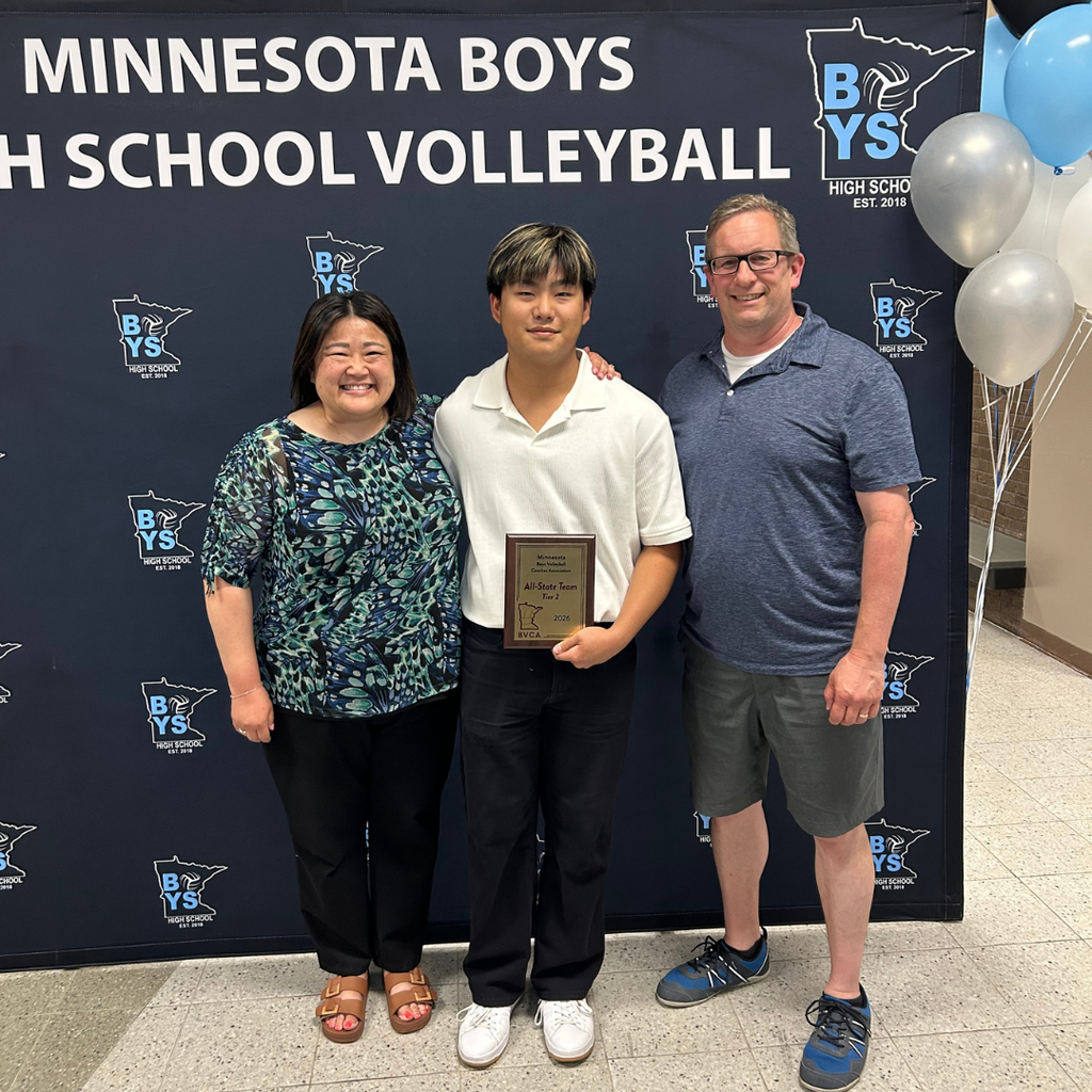 volleyball player holding a plaque standing with his parents