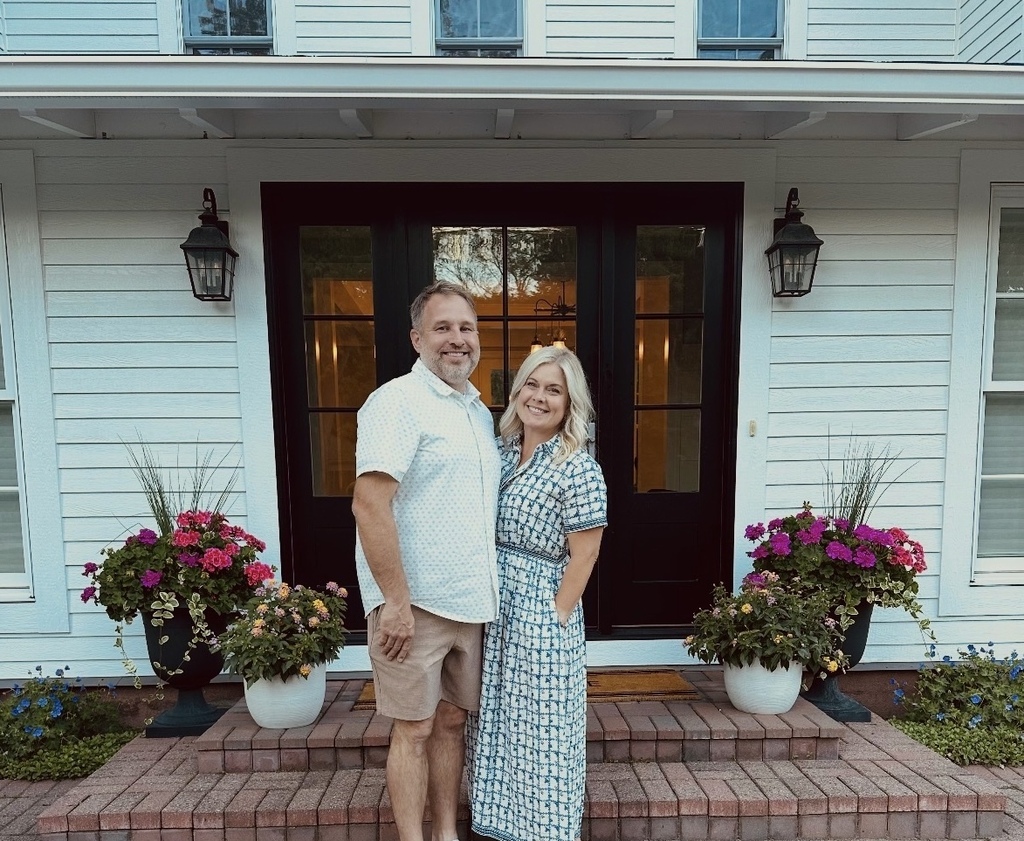 man and woman standing by the front door of a house