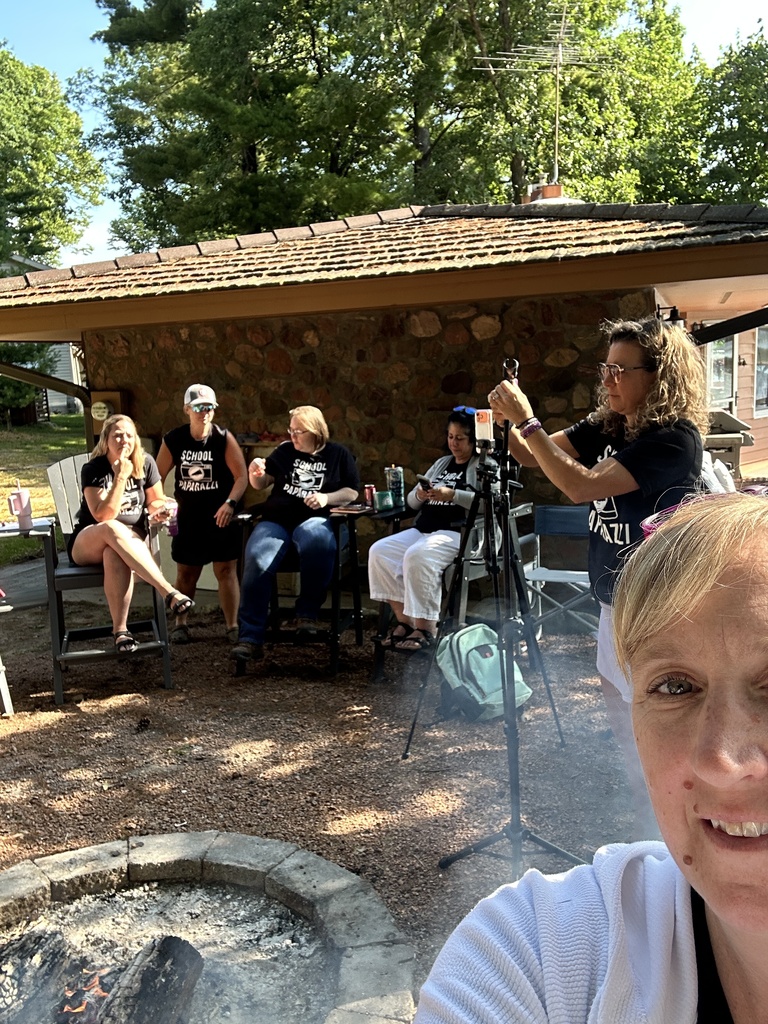 selfie with a campground and people on their phones in the back