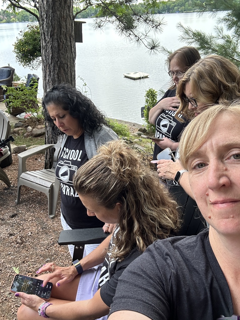 women huddled around someone looking at her phone