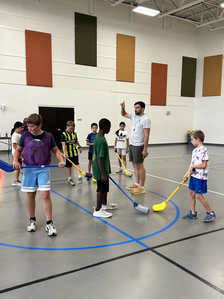 kids playing floor hockey in a gym