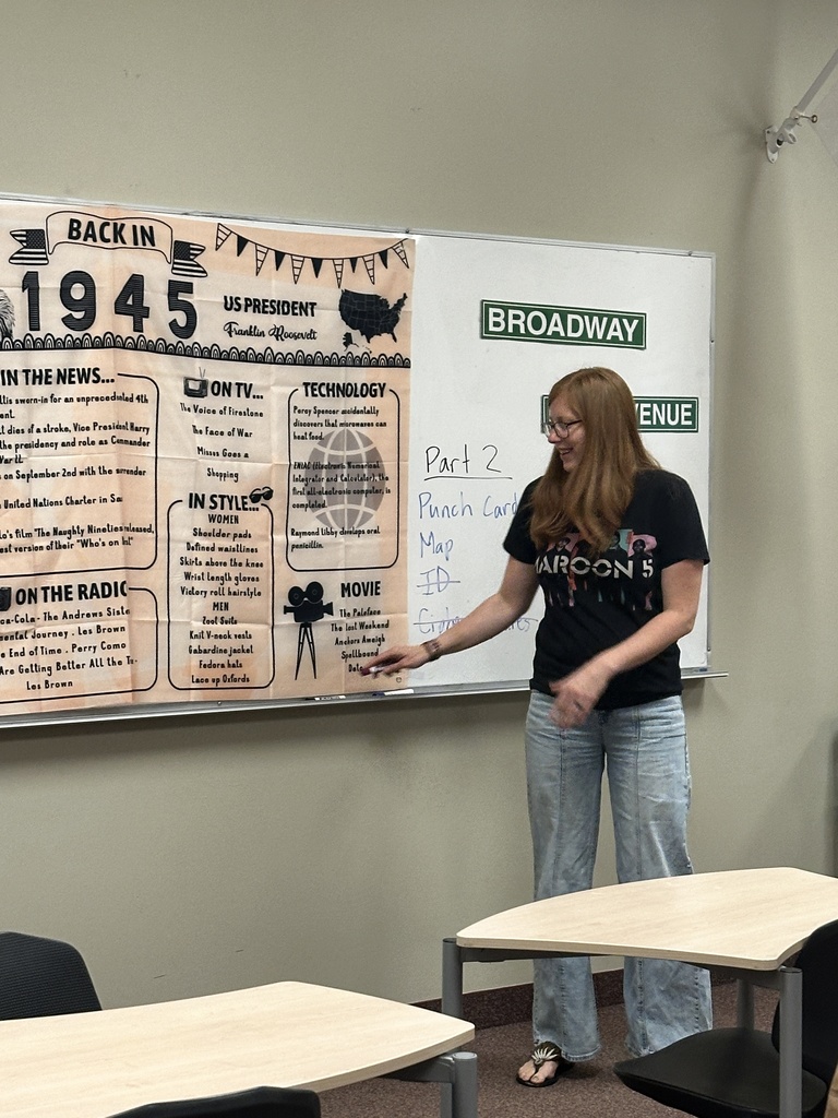 teacher at a whiteboard in the front of a classroom