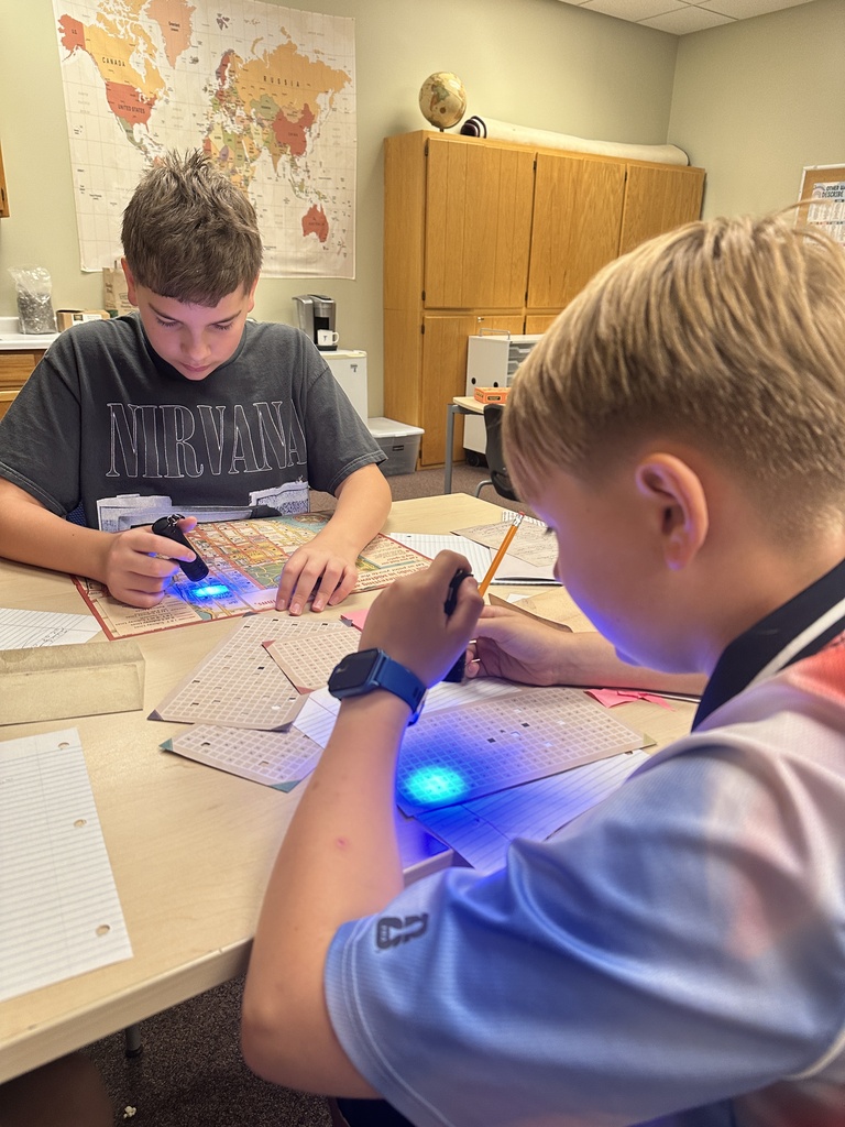 students using black lights to solve puzzles