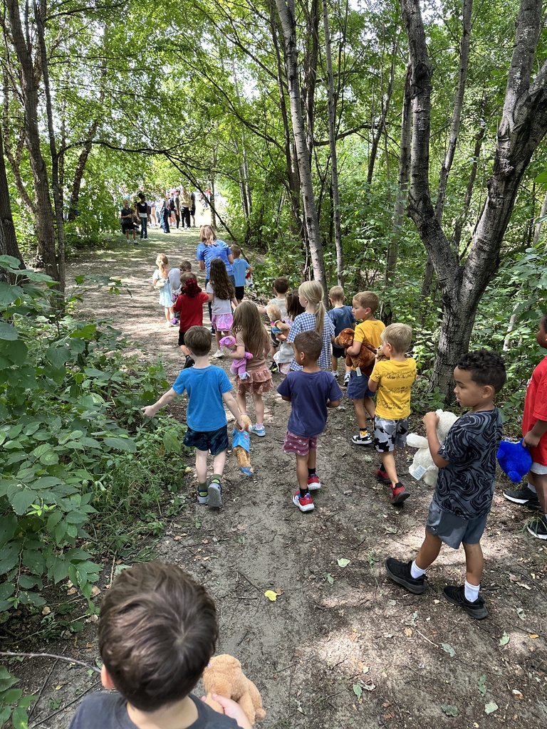 group of kindergarten students walking in the woods