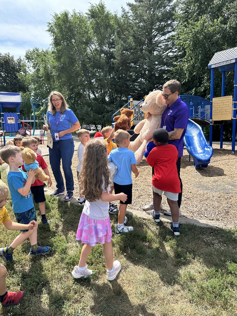 teachers and students standing outside with teddy bears