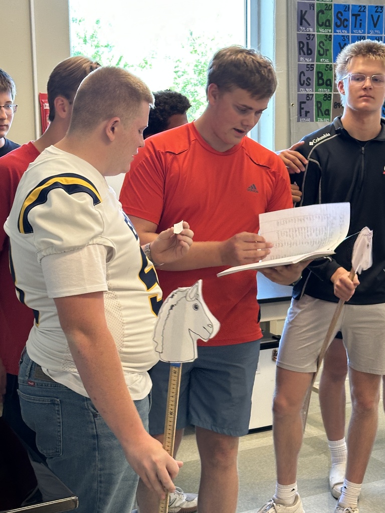 three students looking in a notebook