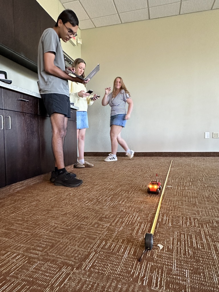 students running an experiment with a battery powered car