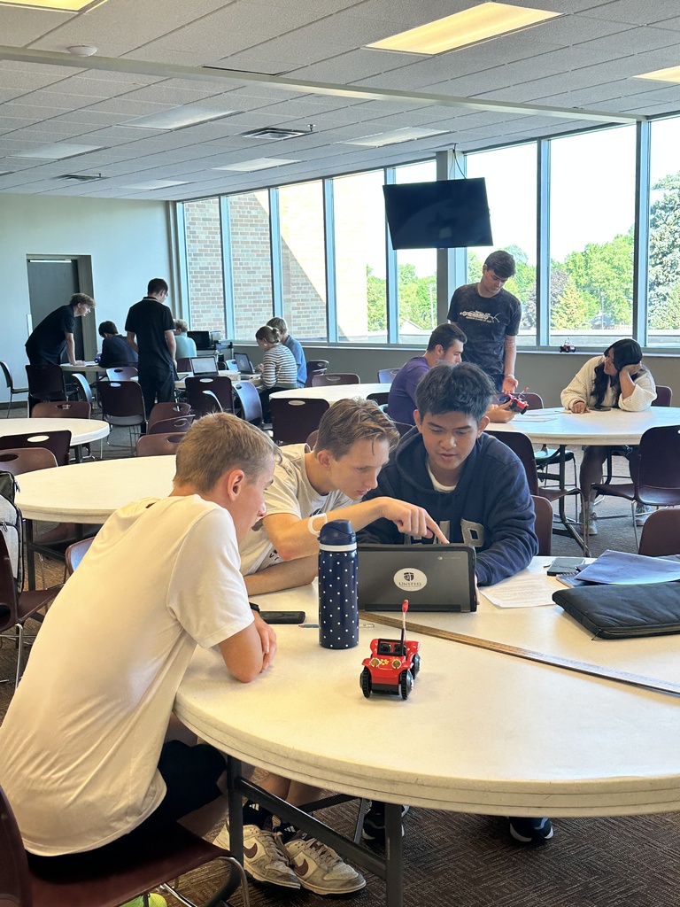 students running an experiment with a battery powered car