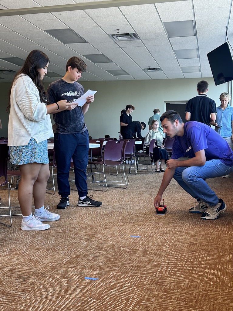 students running an experiment with a battery powered car