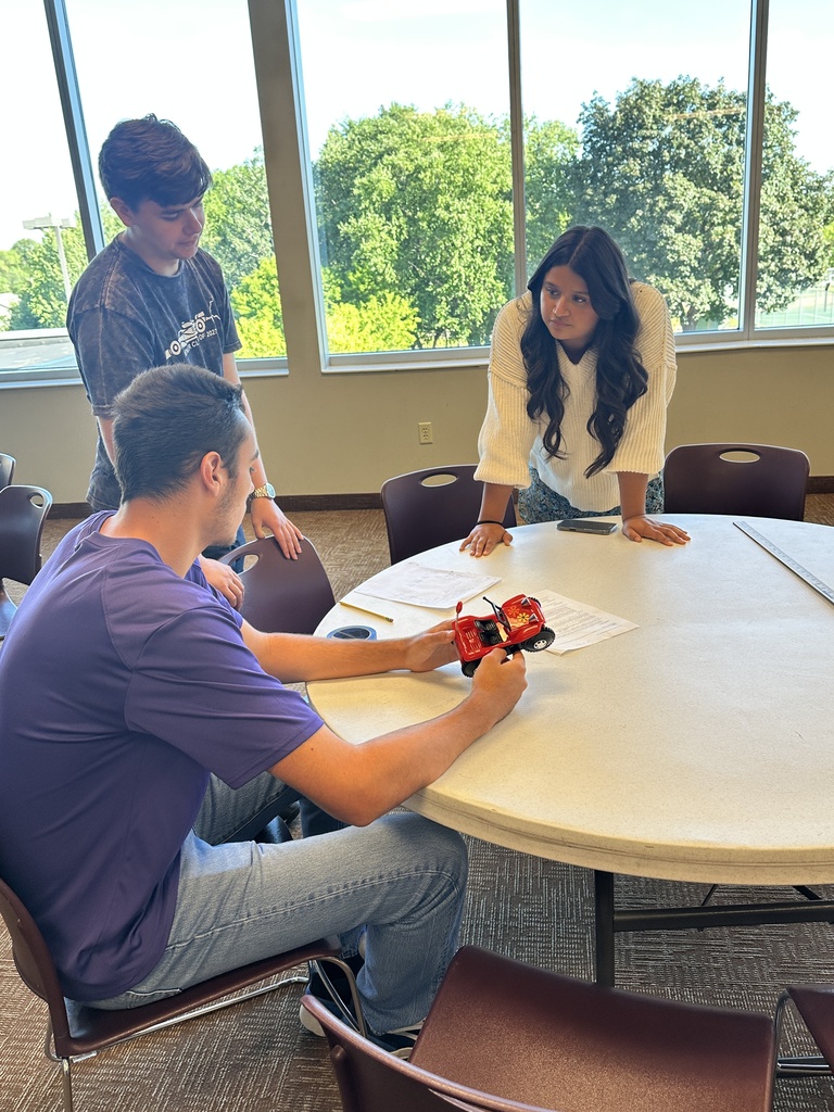 students running an experiment with a battery powered car