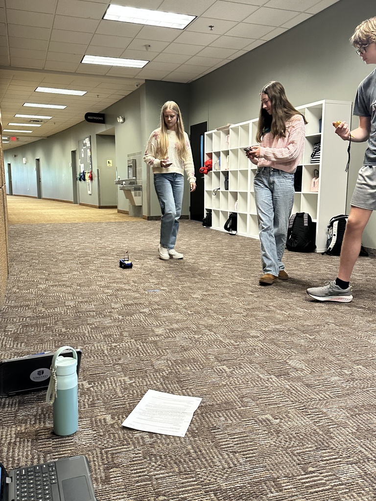 students running an experiment with a battery powered car