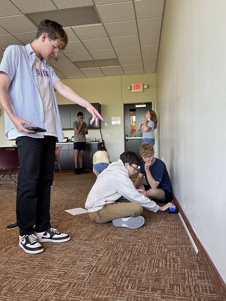students running an experiment with a battery powered car