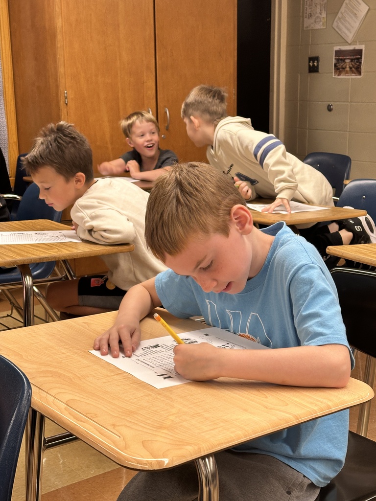 elementary boys sitting at their desks doing a word search