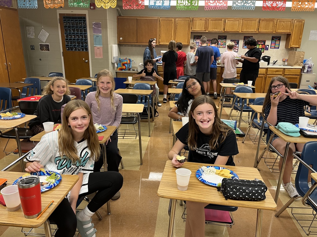 students sitting at their desks eating food