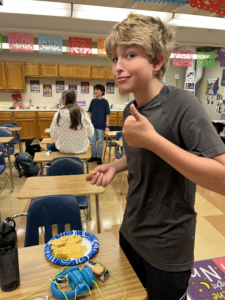 boy with a plate of chips giving a thumbs up