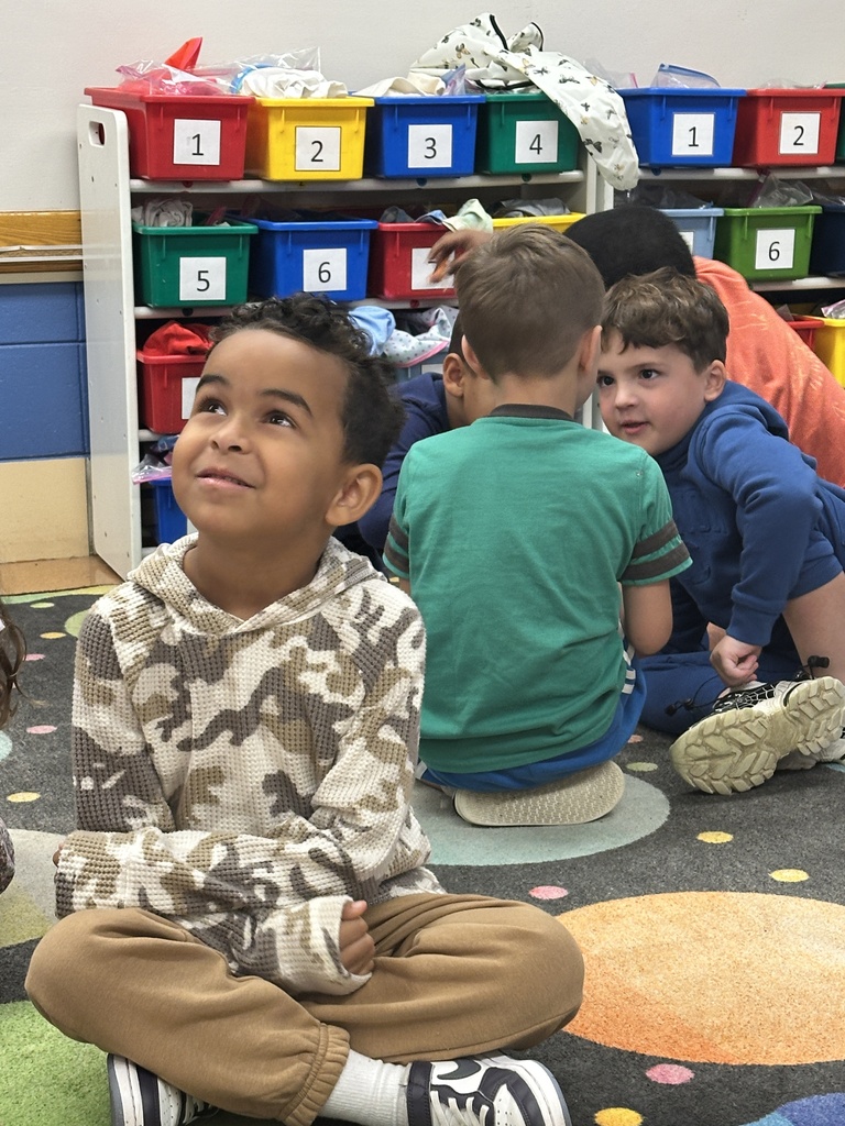 male students sitting on the floor talking in small groups
