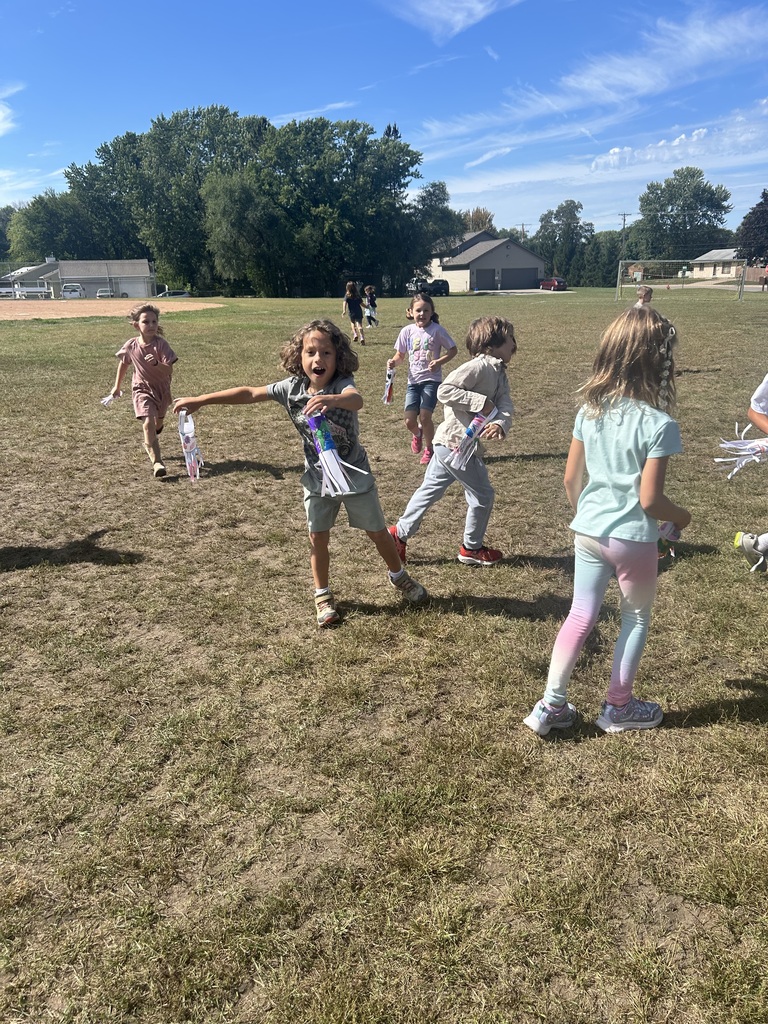 1st grade students playing with their handmade windsocks outside