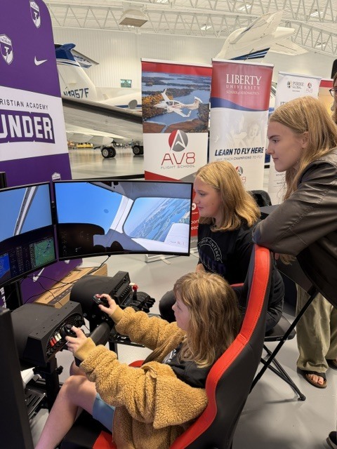 three girls on a flight simulator