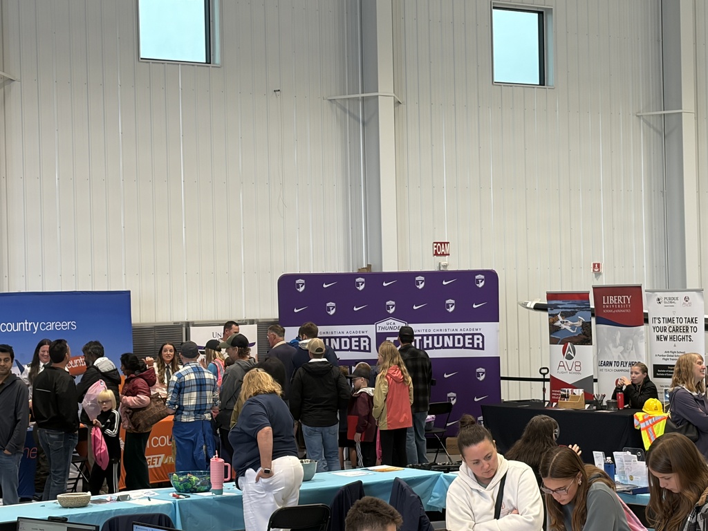 crowd of people visiting booths at an expo