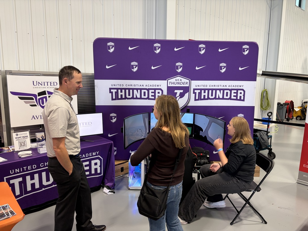 man talking to a woman standing near a flight simulator