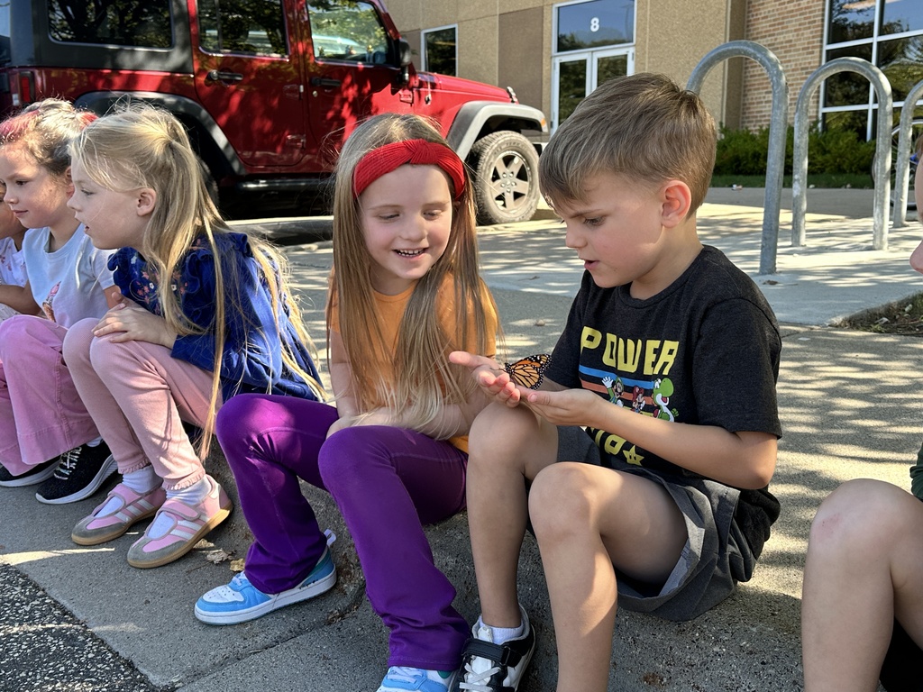 kindergarten students holding a monarch butterfly