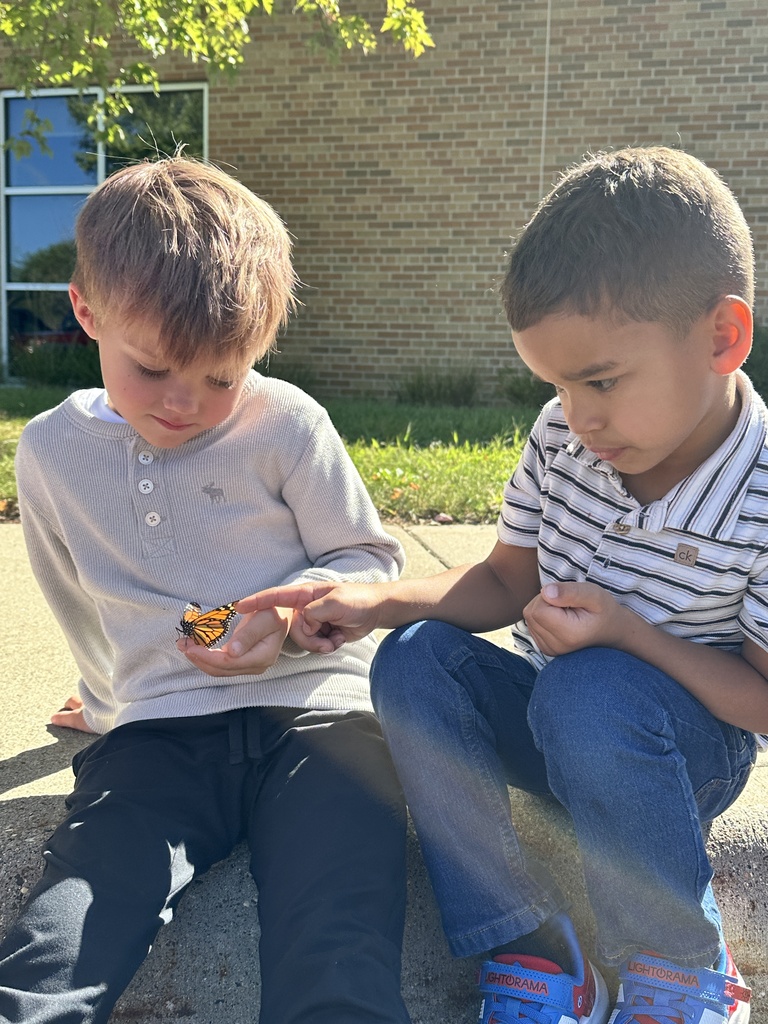 kindergarten students holding a monarch butterfly