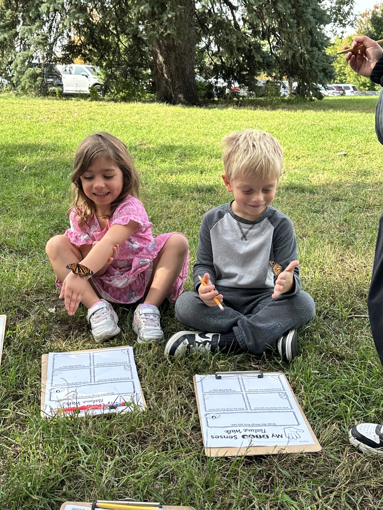 kindergarten students holding a monarch butterfly
