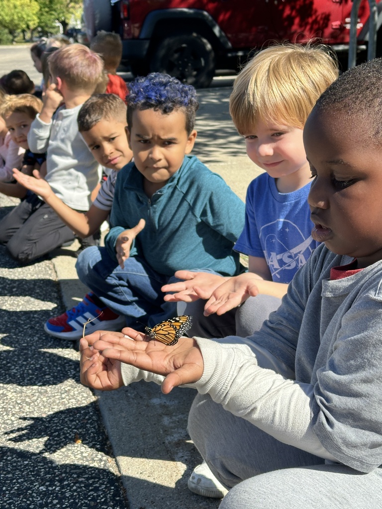 kindergarten students holding a monarch butterfly