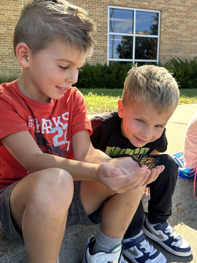 kindergarten students holding a monarch butterfly