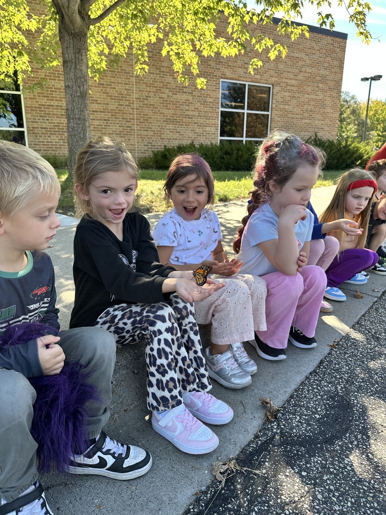 kindergarten students holding a monarch butterfly