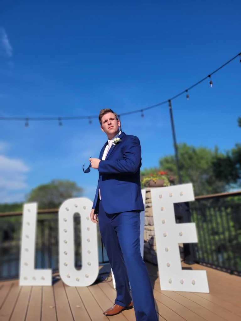 man in a suit holding sunglasses