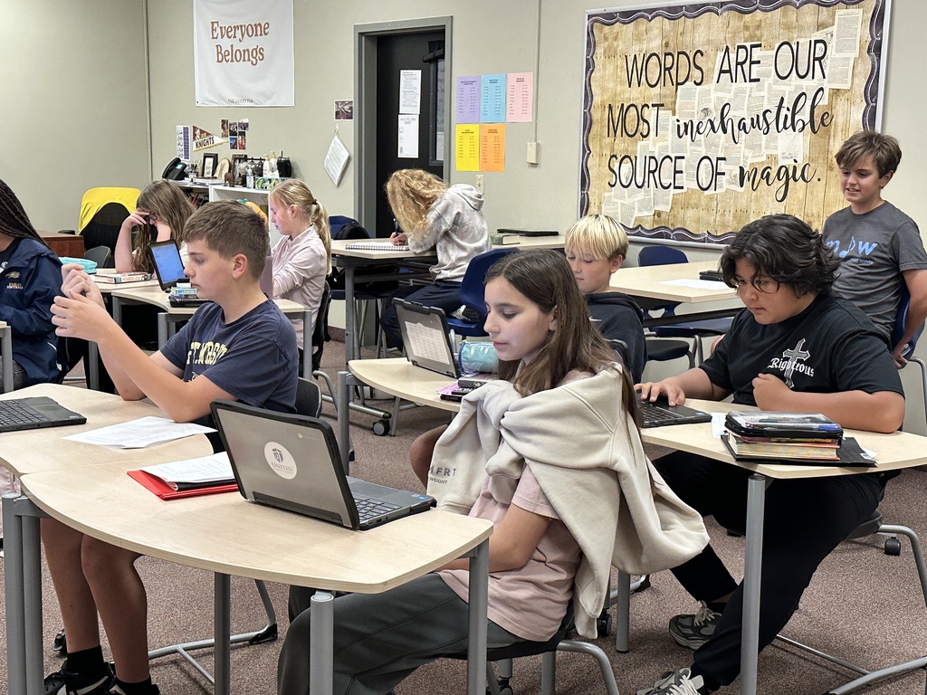 students sitting at desks working on laptops