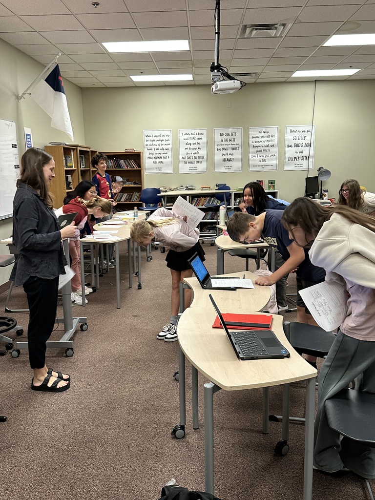 students in a classroom bowing to a teacher acting as a judge in a mock trial