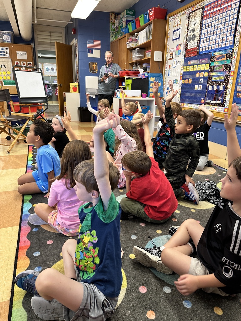 kindergarten students raising their hands