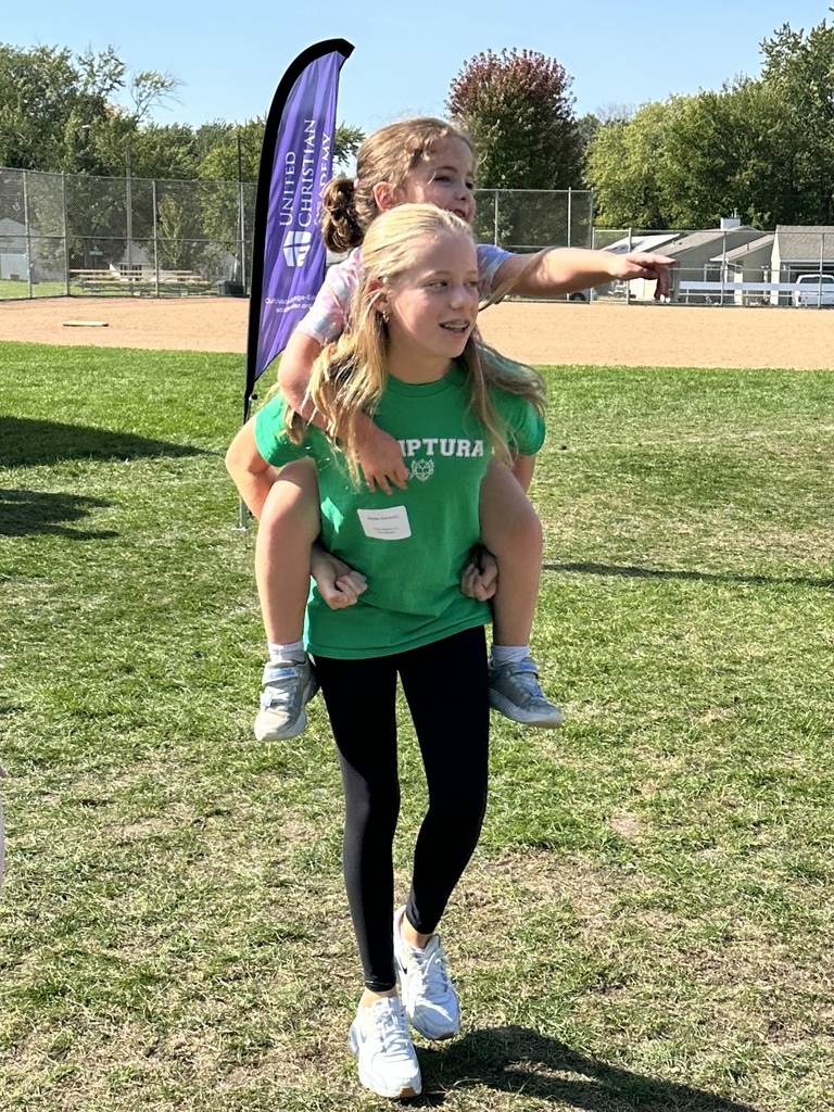 middle school student with an elementary student riding on her back