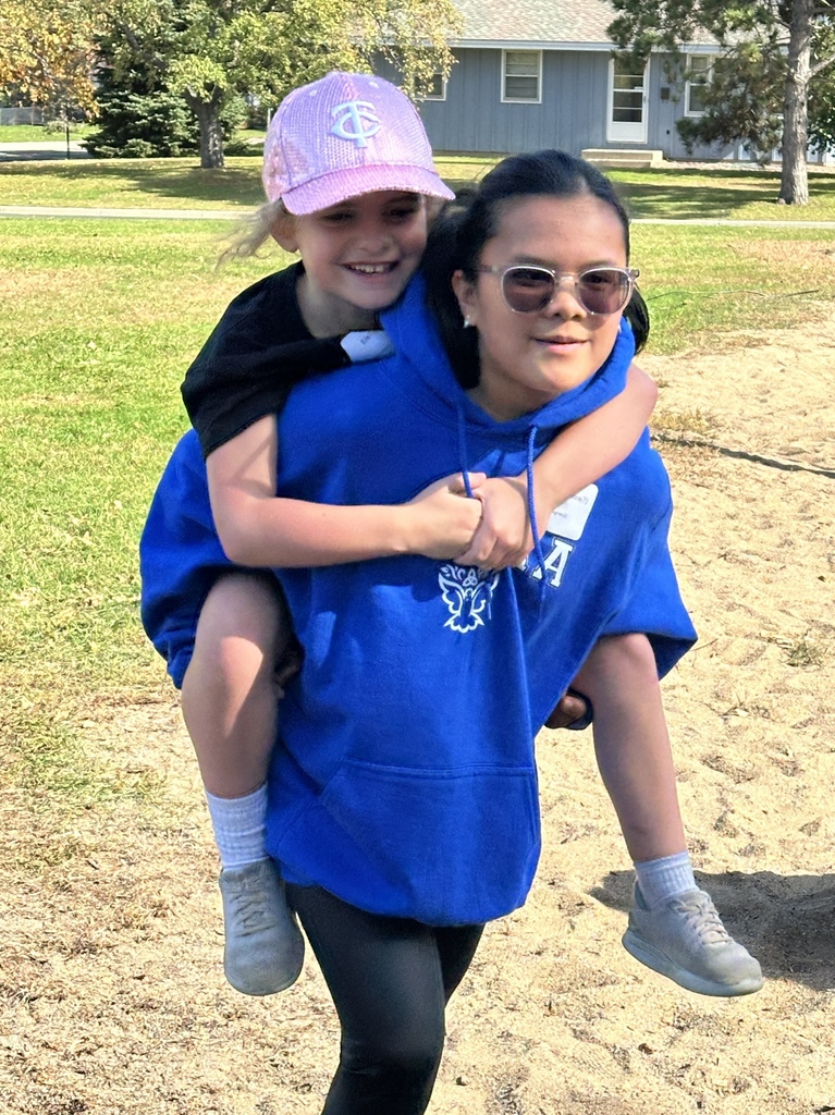 middle school student with an elementary student riding on her back