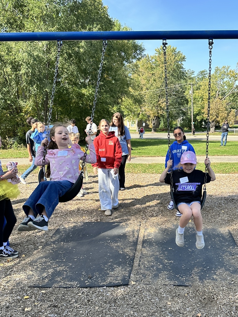 older students pushing younger students on the swings
