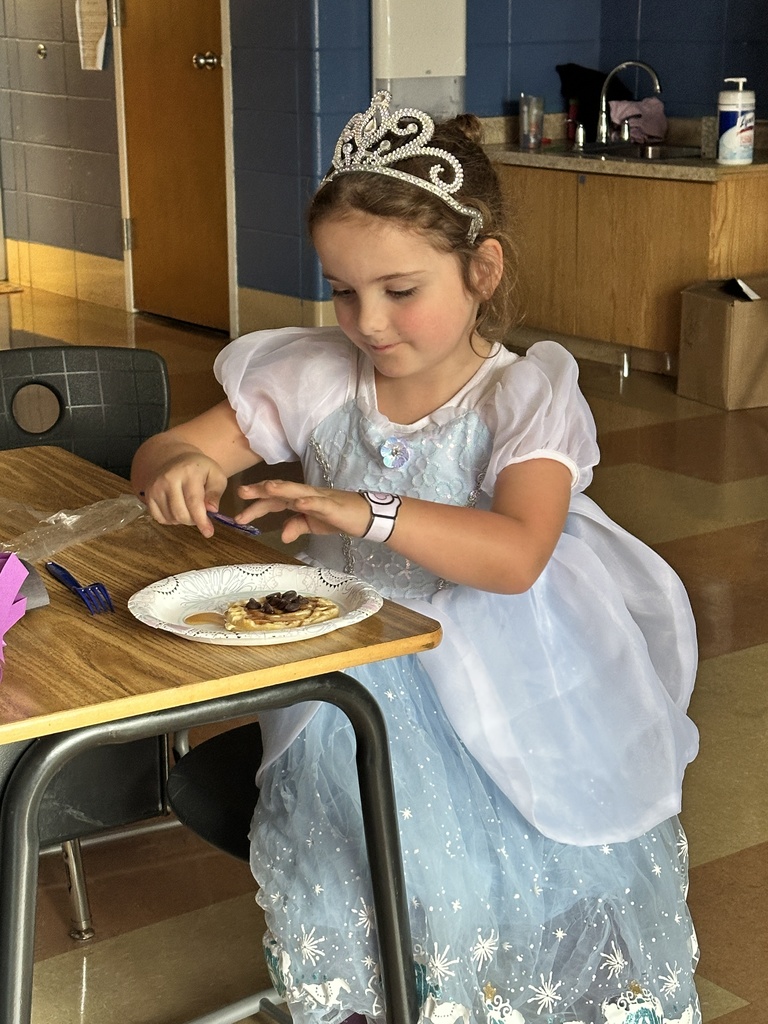 girl dressed as a princess eating a waffle