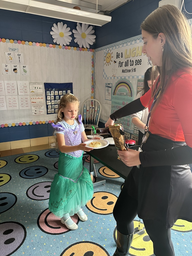teacher pouring syrup on a waffle for a student