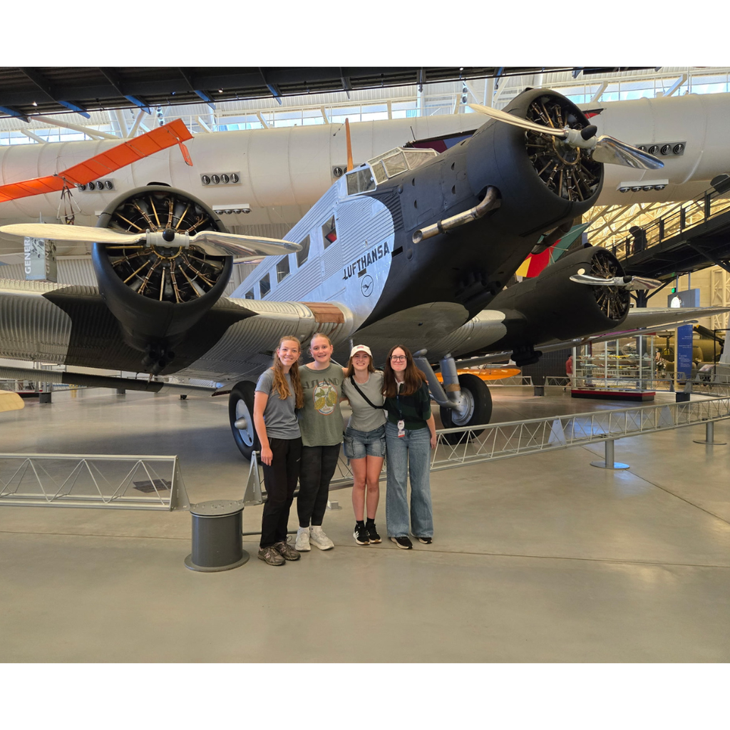 students in front of an airplane in a museum