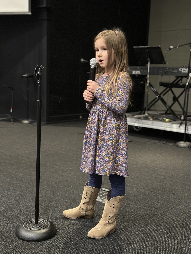 young girl singing into a microphone