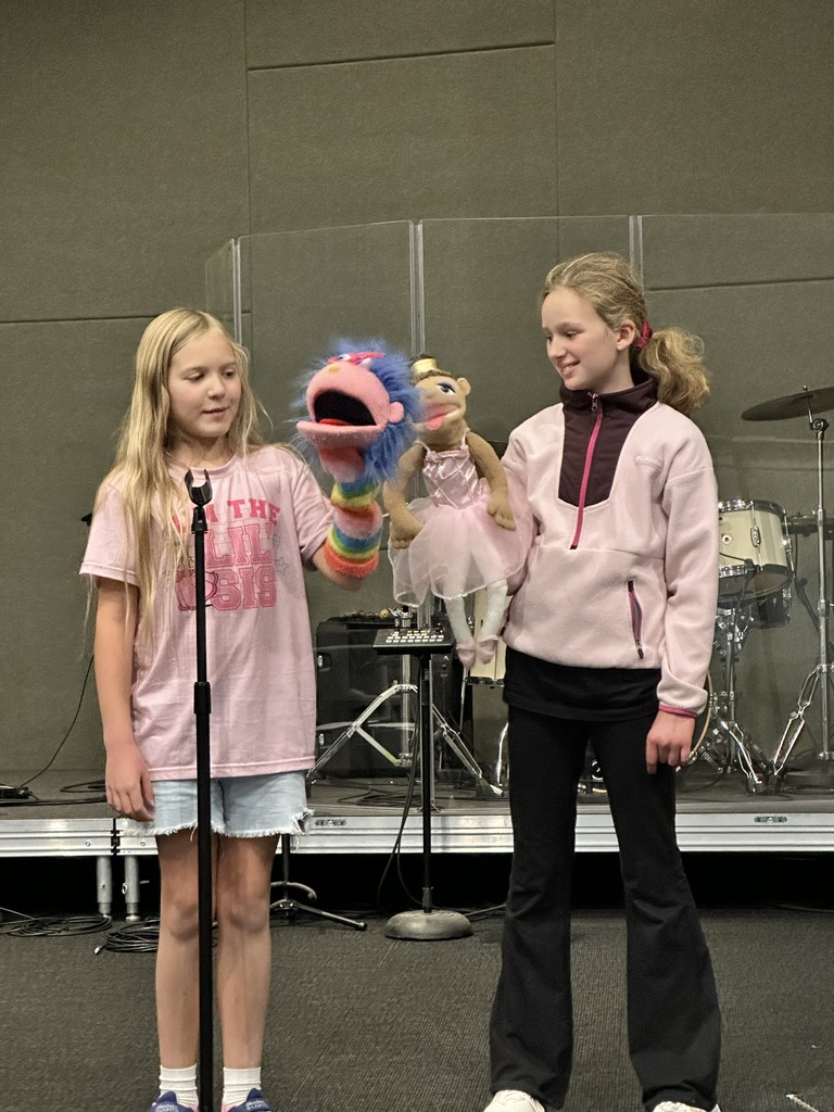 two girls holding puppets