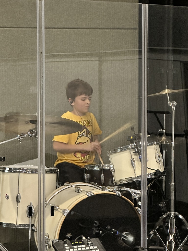 young boy playing a drumset