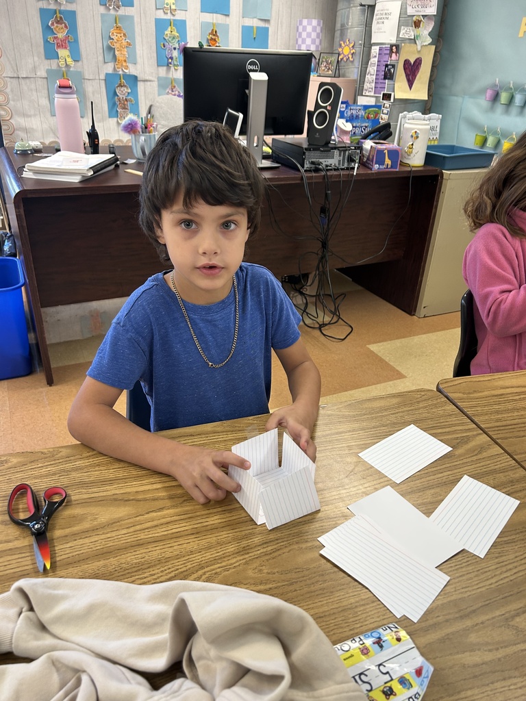student building a tower out of notecards